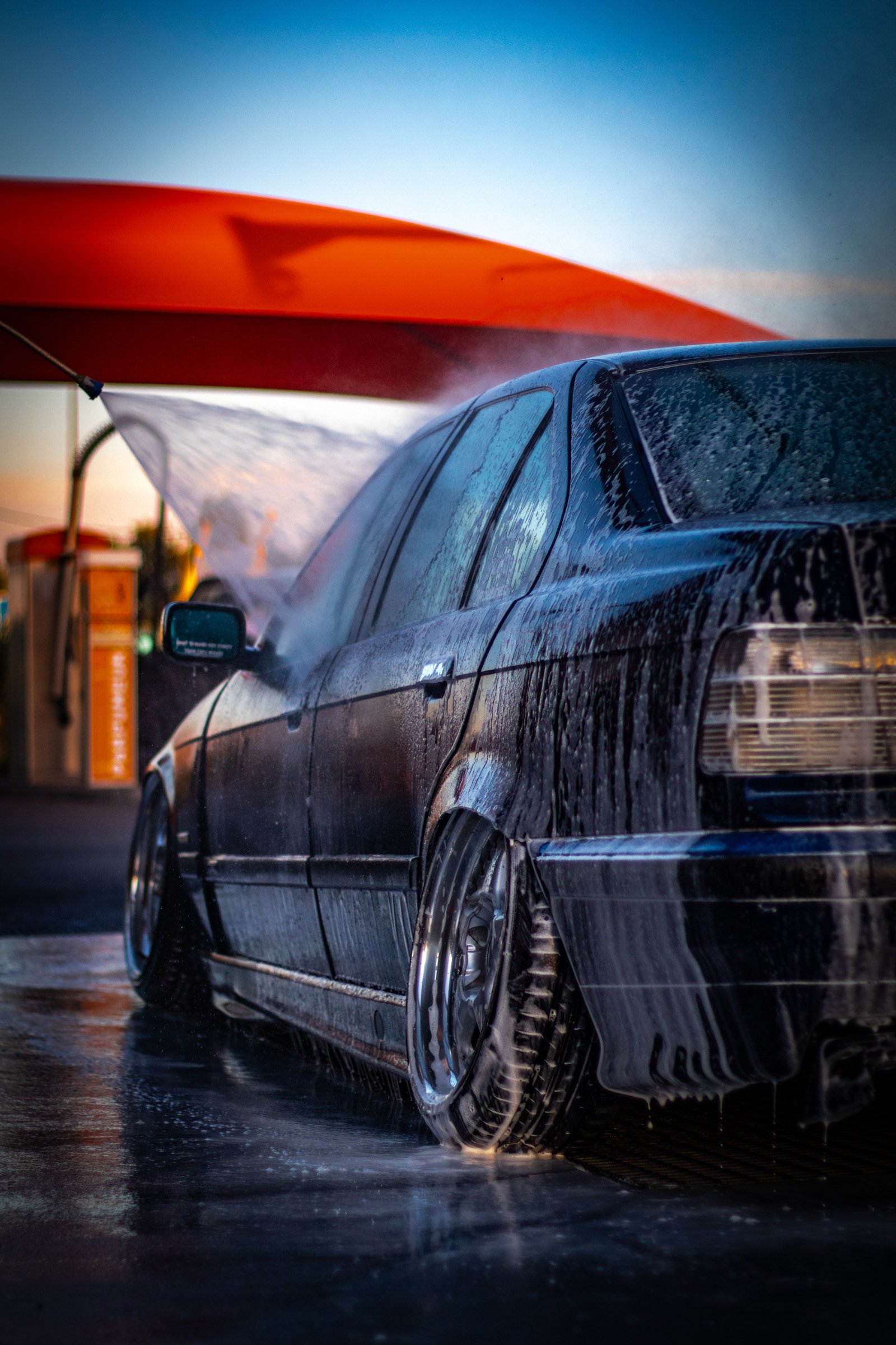 Mobile car wash technician hand-washing a car at a villa doorstep in Dubai